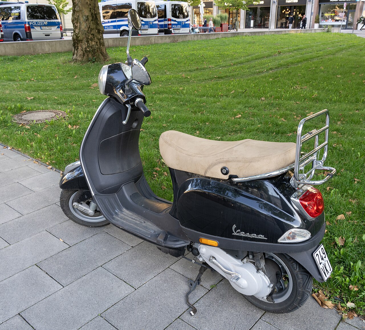 Una Vespa roja aparcada en una calle italiana