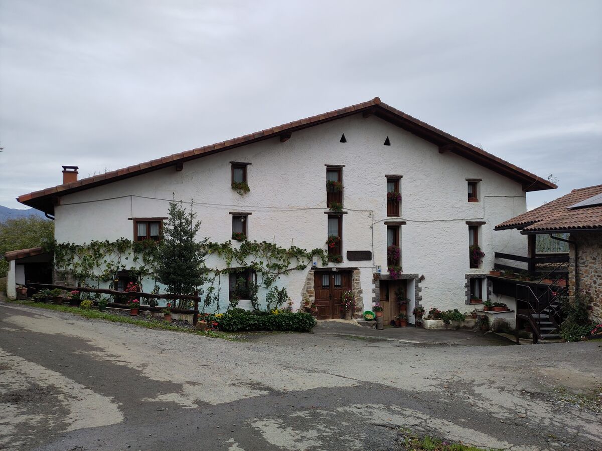 Caserío vasco con tejado a dos aguas y fachada encalada