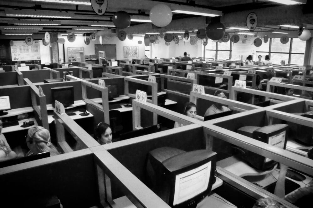 Sala de un centro de llamadas con puestos separados por mamparas