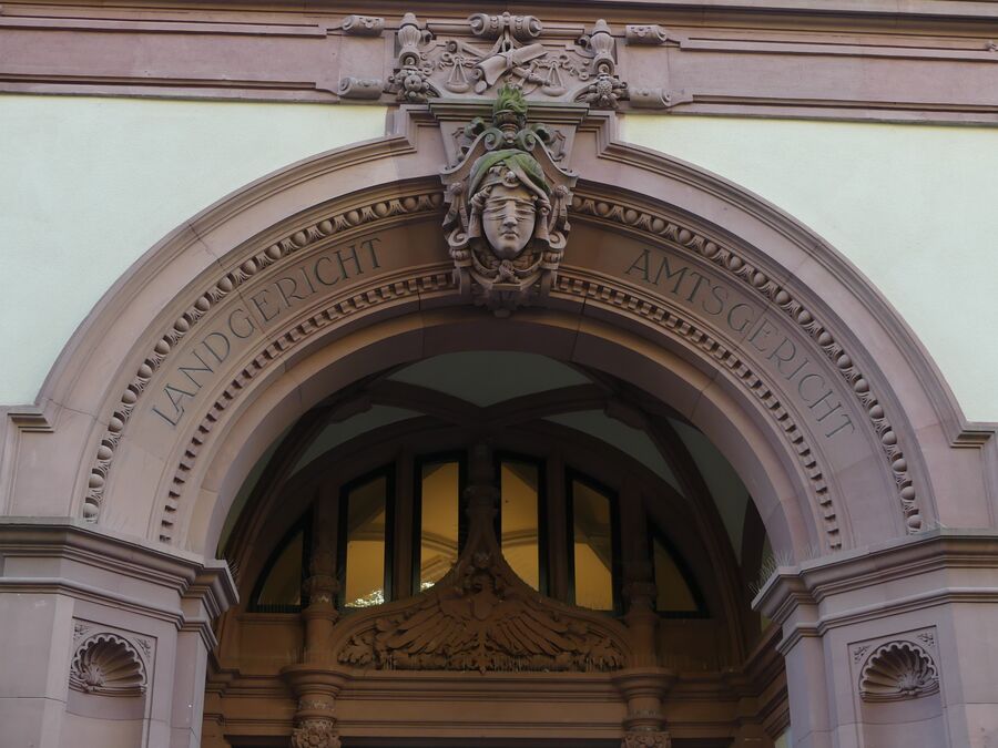 Fachada de un edificio judicial con la figura de la Justicia sobre el arco
