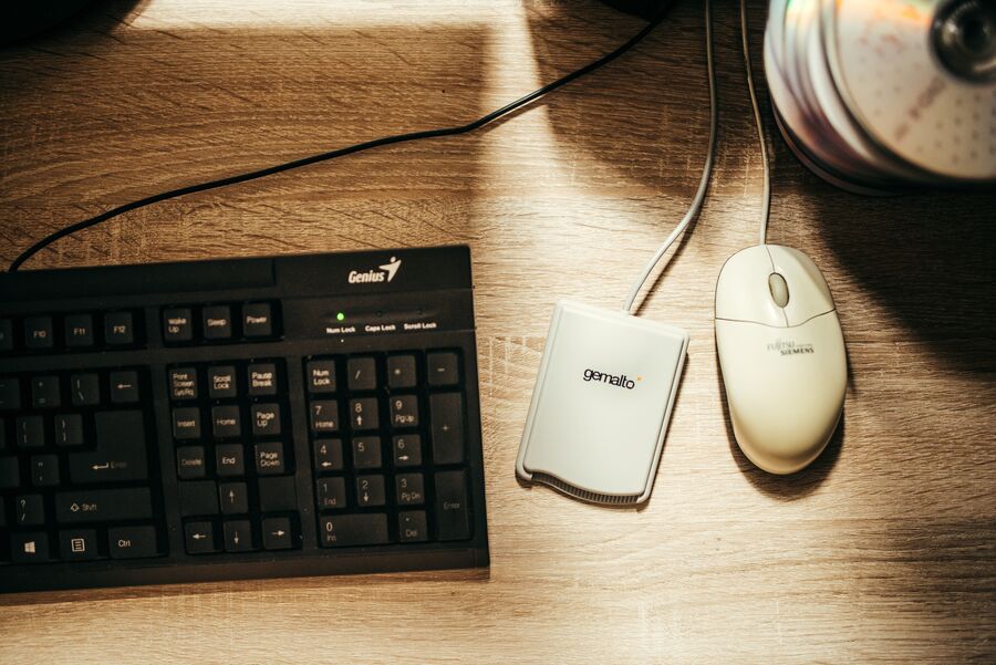 Teclado, ratón y lector de tarjetas sobre una mesa de trabajo
