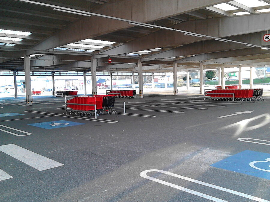 Interior de un aparcamiento cubierto con plazas marcadas y vacías