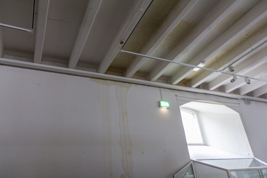 Pared y techo de un edificio con regueros amarillentos dejados por una filtración de agua
